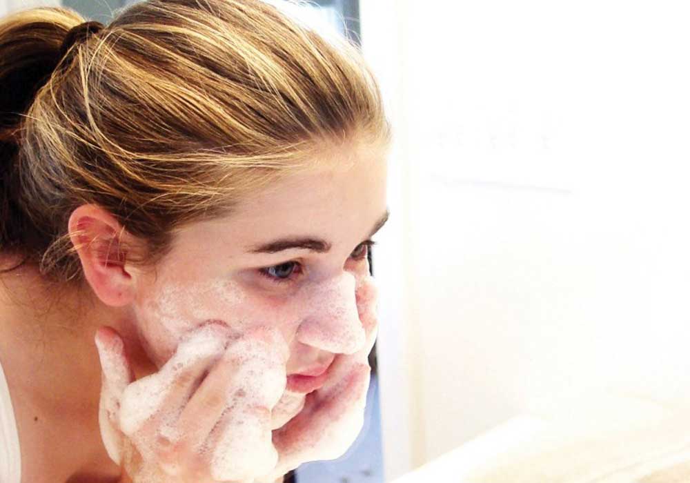 Teenage girl washing her face